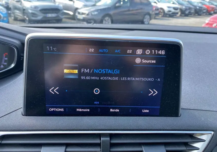 Écran central tactile du Peugeot 3008 blanc, affichant la radio FM Nostalgie, vue intérieure frontale.