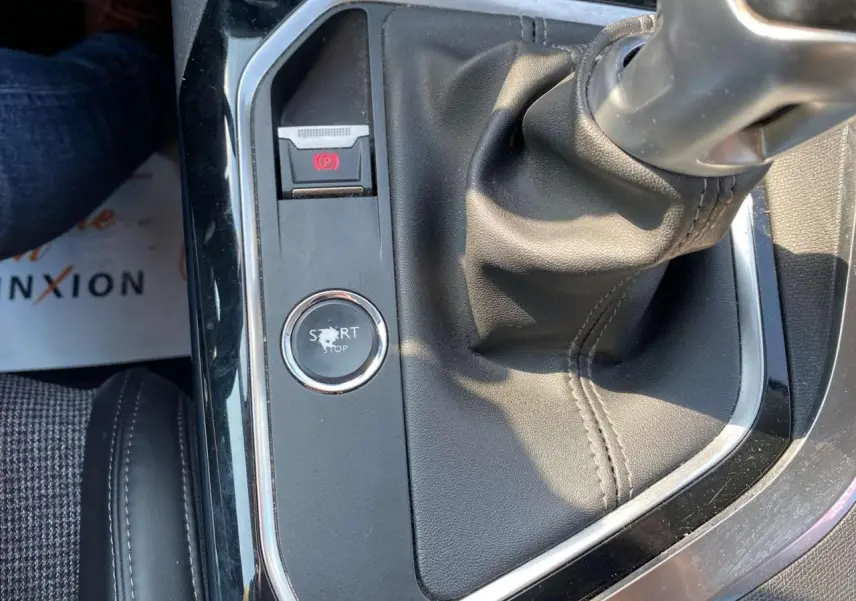 Gros plan intérieur sur la console centrale noire avec levier de vitesse manuel et bouton start/stop du Peugeot 3008 blanc.
