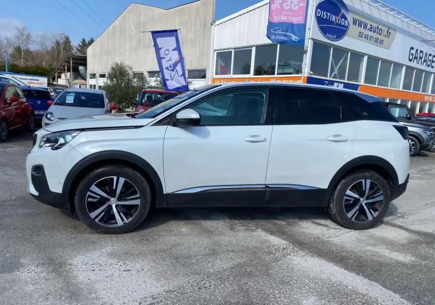 Vue de profil côté gauche d'un Peugeot 3008 blanc Banquise, avec toit noir et jantes alliage bicolores, stationné en extérieur.