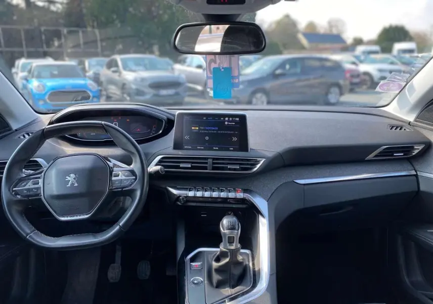 Vue intérieure avant du Peugeot 3008 blanc de 2018, mettant en valeur le tableau de bord et la boîte manuelle.