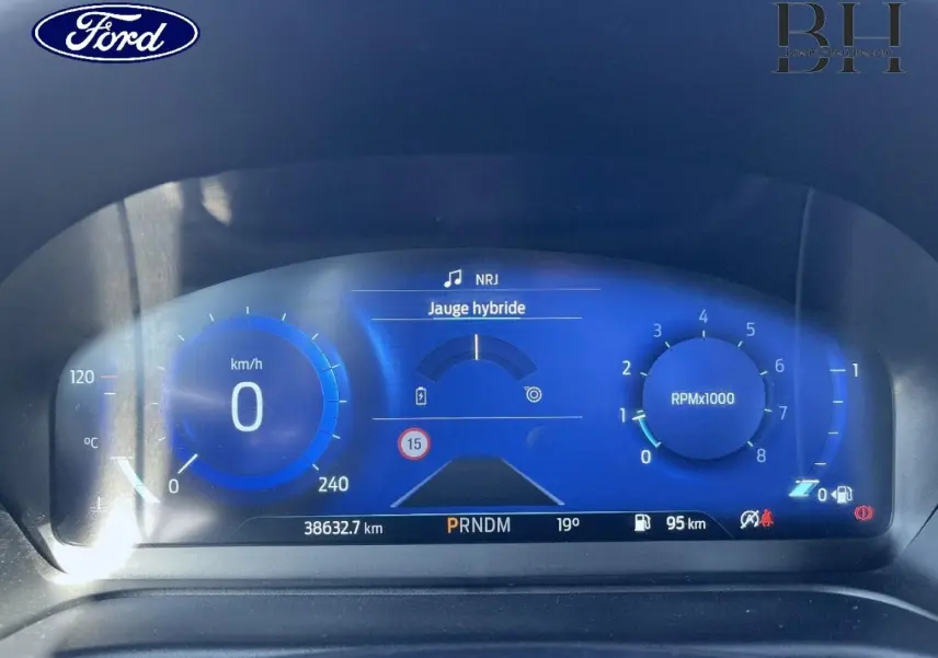 Tableau de bord numérique bleu du Ford Puma 2022, affichant vitesse, jauge hybride et compte-tours RPM.