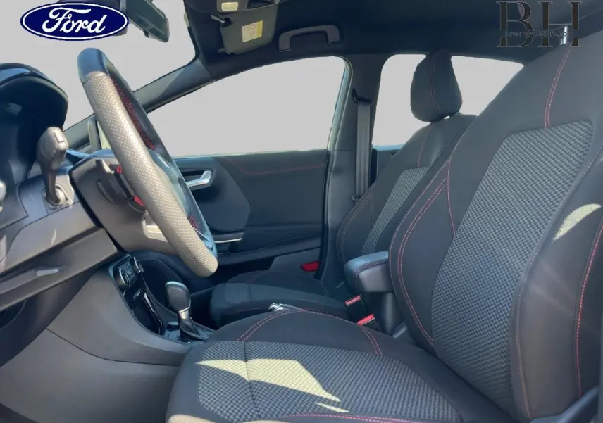 Vue intérieure côté conducteur du Ford Puma 2022, sièges noirs avec surpiqûres rouges et volant sport multifonction.