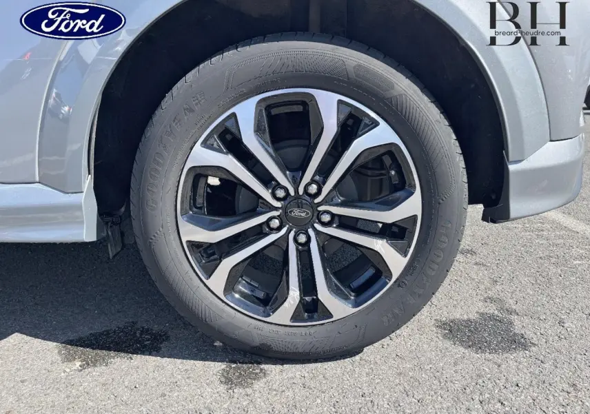 Gros plan sur la roue avant gauche avec jante alu bicolore du Ford Puma gris Solar métallisé.