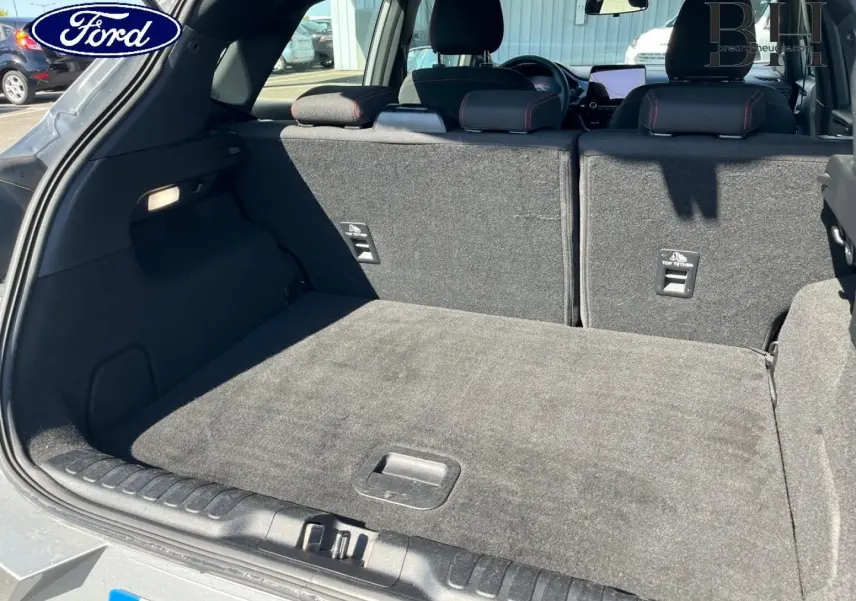 Coffre ouvert du Ford Puma gris Solar métallisé, vue arrière montrant la banquette arrière et le plancher de coffre plat.