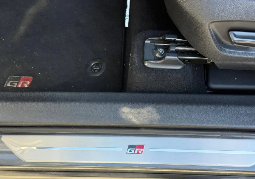 Détail de la plaque de seuil et tapis de sol noirs avec logo GR du Toyota C-HR 2.0 Hybride gris Atlas bi-ton.