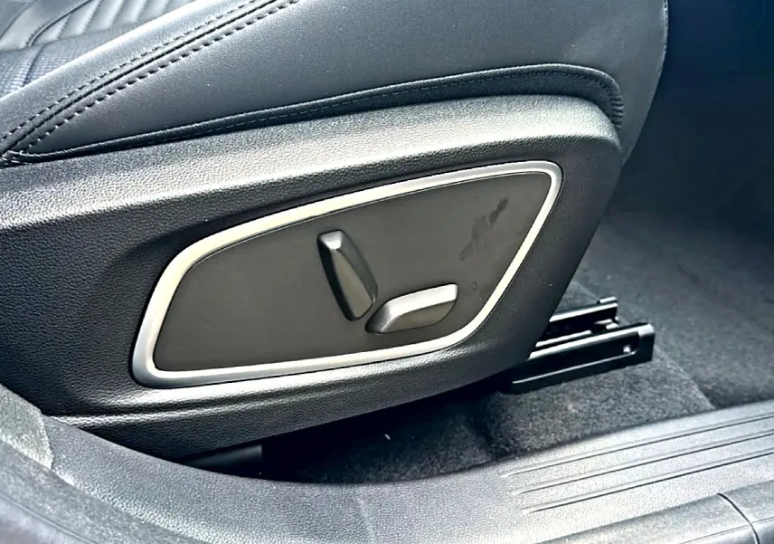 Gros plan sur les commandes électriques du siège conducteur noir du Renault Austral 2026 version hybride.