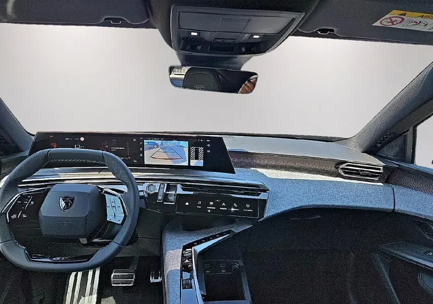 Vue intérieure avant du Peugeot 3008 noir 2026, mettant en valeur le tableau de bord numérique et le volant multifonction cuir.