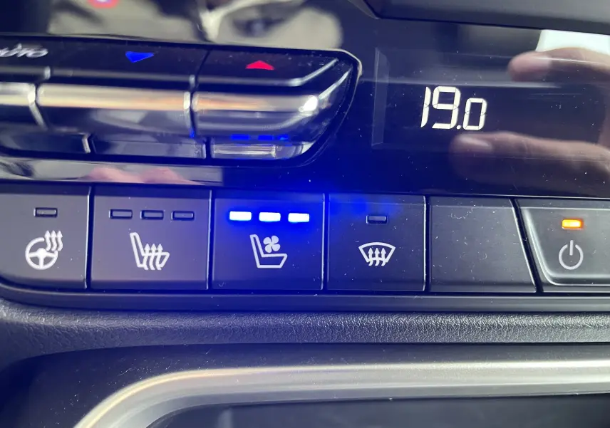 Gros plan sur les commandes de climatisation et sièges ventilés du Mazda CX-60 2023, affichage digital à 19°C.