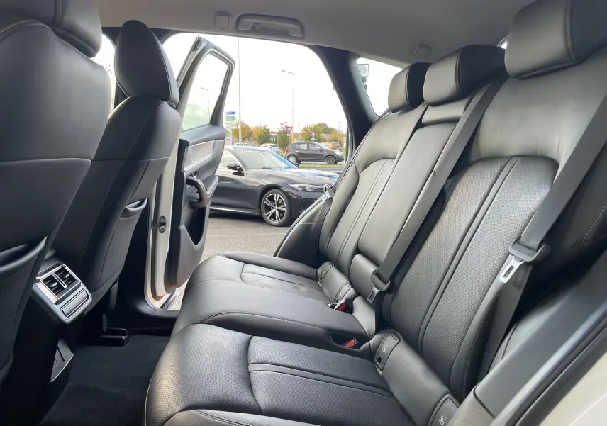 Vue intérieure côté droit sur les sièges arrière en cuir noir du Mazda CX-60 blanc nacré avec porte ouverte.