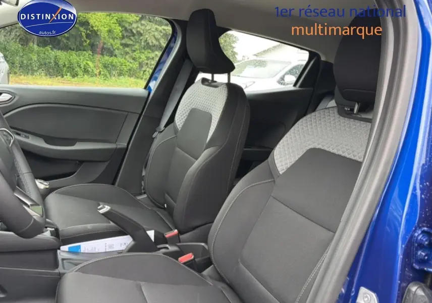 Vue intérieure côté droit de la Renault Clio V bleu iron, montrant les sièges avant en tissu bi-ton gris et noir.