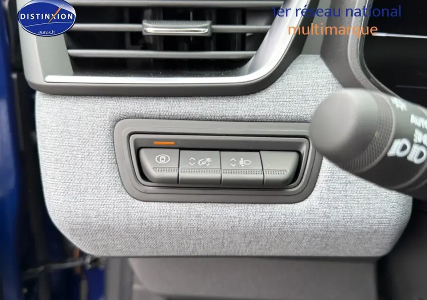 Détail des commandes de réglage des feux et verrouillage sur tableau de bord gris clair d’une Renault Clio V Bleu iron.