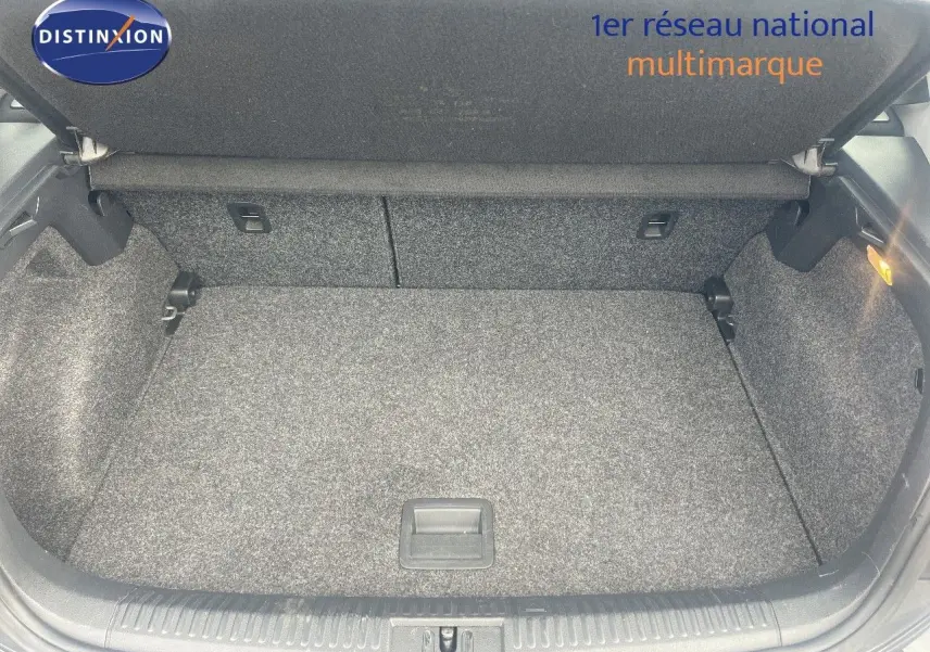 Coffre ouvert vu de l'arrière d'une Volkswagen Polo noire 2016, montrant un espace de chargement propre et tapissé.