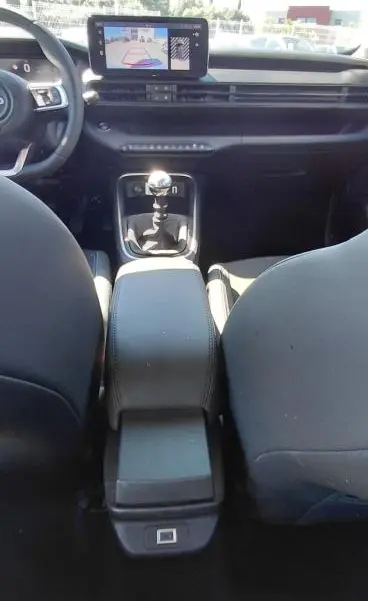 Vue intérieure avant du Jeep Avenger 2025 blanc, montrant la console centrale avec boîte manuelle et écran tactile.