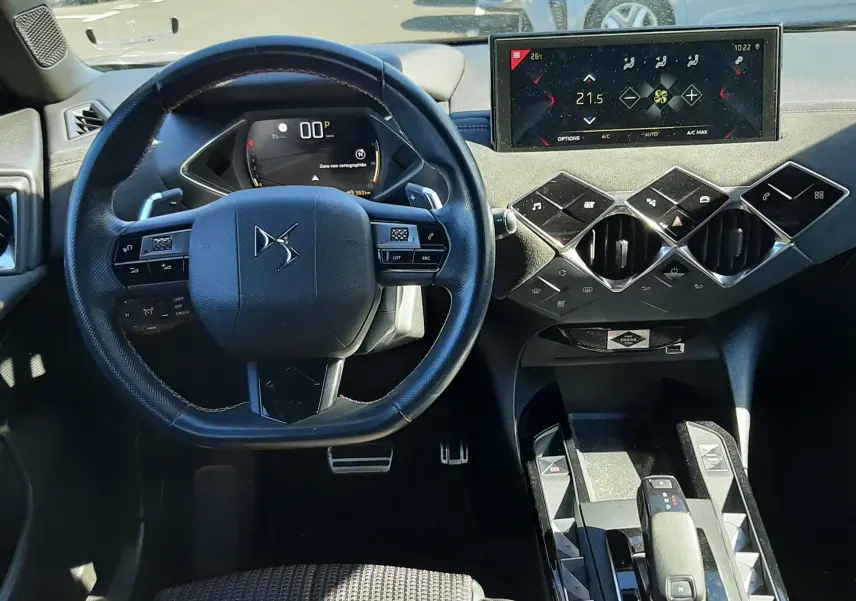 Vue intérieure du tableau de bord et volant du DS3 Crossback gris foncé, avec écran tactile et commandes modernes.