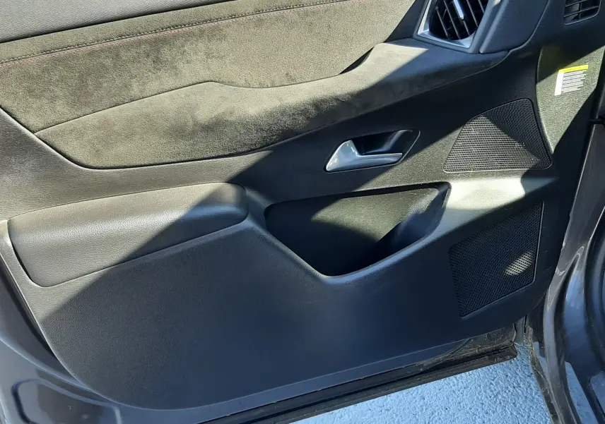 Intérieur côté gauche de la porte avant d'un DS3 Crossback gris foncé, avec garniture noire et insert en alcantara.