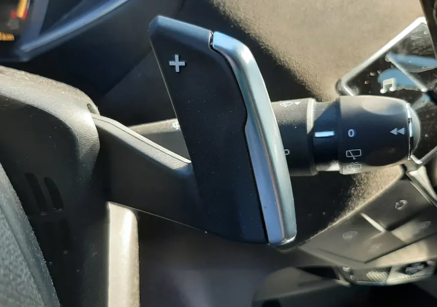 Gros plan sur la palette de changement de vitesse + côté droit du volant dans l'habitacle noir d'un DS3 Crossback gris foncé 2021.