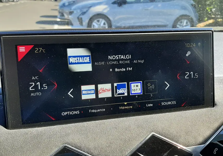 Vue intérieure du tableau de bord du DS3 Crossback avec écran tactile affichant la radio FM et commandes climatisation à 21,5°C.