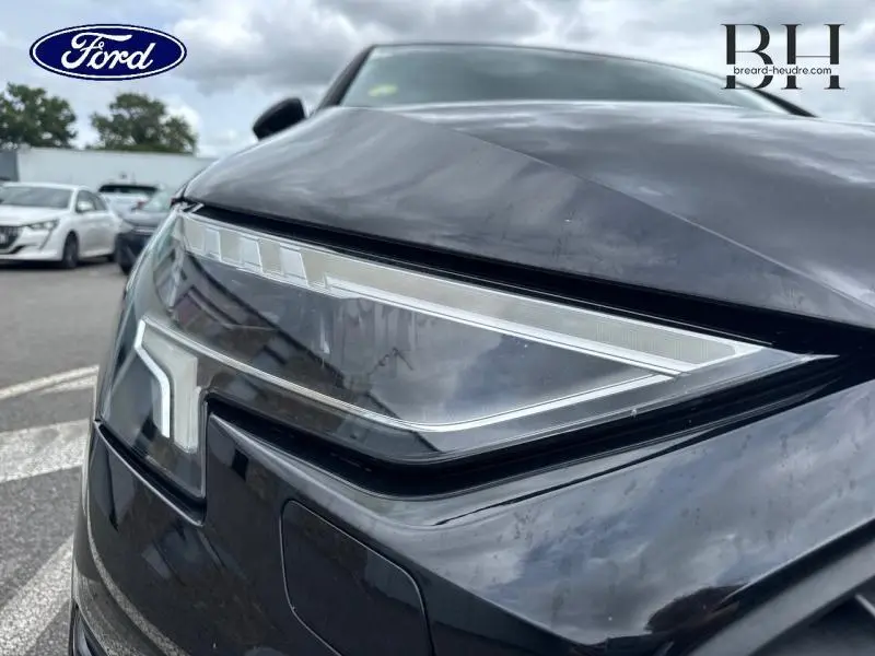 Gros plan sur le phare avant droit noir Mythic métallisé de l'Audi A3 Sportback 35 TDI 2022 avec signature LED distinctive.