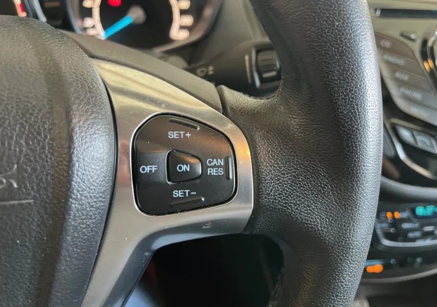 Gros plan sur les commandes de régulateur de vitesse au volant cuir noir d'une Ford B-MAX titanium 2015.