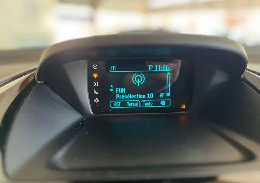 Écran central de la radio affichant la station FM dans une Ford B-MAX gris clair de 2015.