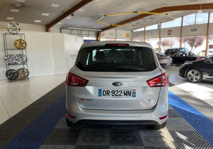 Vue arrière d'une Ford B-MAX gris clair 2015 dans un showroom lumineux avec plaques d'immatriculation françaises.