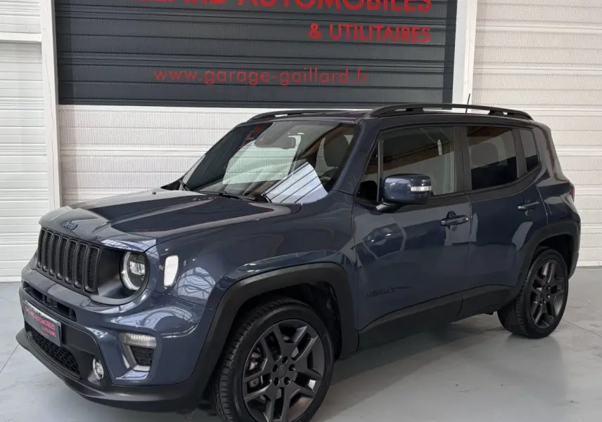 Jeep Renegade bleu vue 3/4 avant droit avec jantes noires et toit noir en intérieur de garage.
