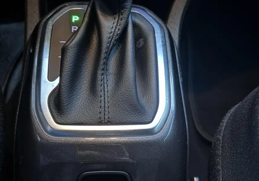 Le levier de vitesses automatique noir et chrome de la Jeep Renegade hybride rechargeable vue de dessus, avec boutons de frein et contrôle de stabilité.