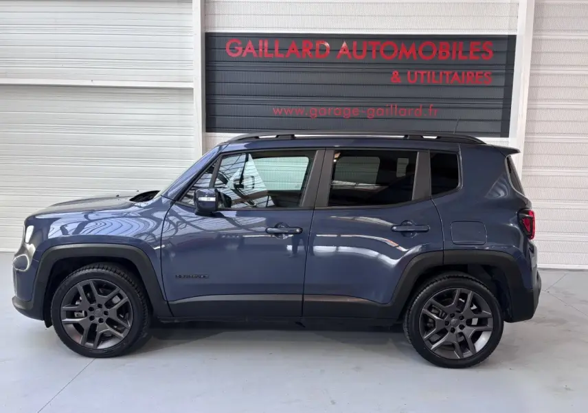 Profil latéral droit d'un Jeep Renegade bleu hybride rechargeable 2021 avec jantes foncées et toit noir.