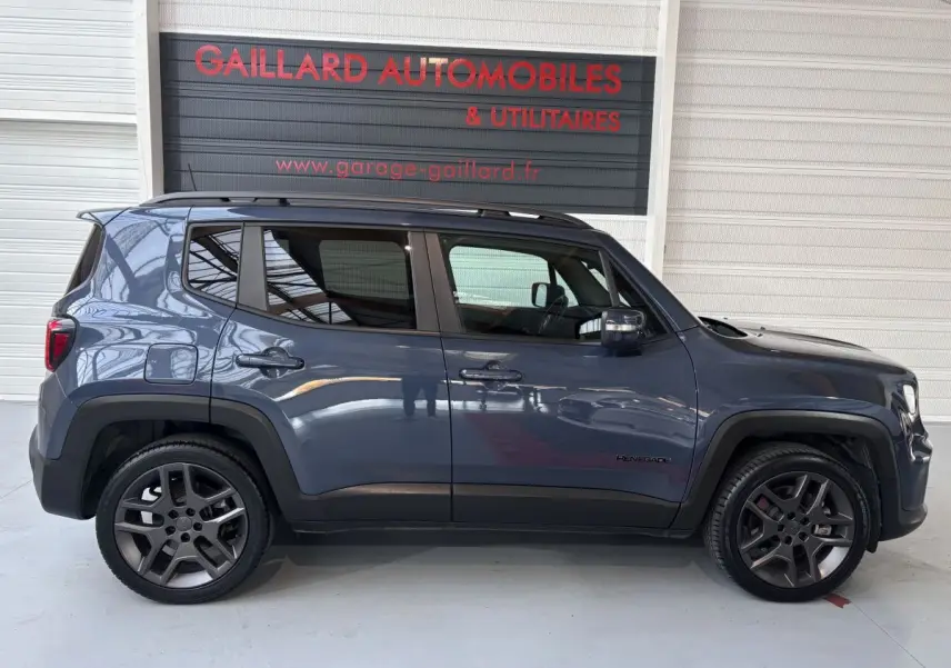 Profil côté gauche d'un Jeep Renegade bleu hybride rechargeable 2021 avec jantes foncées et toit noir.