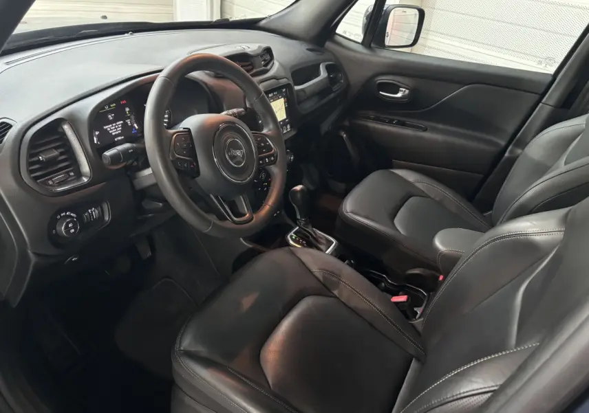 Intérieur avant noir du Jeep Renegade 2021, vue côté conducteur avec volant cuir et écran tactile central.