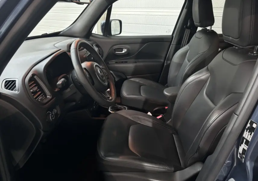 Intérieur avant droit du Jeep Renegade bleu 2021 avec sièges cuir noirs et tableau de bord moderne.