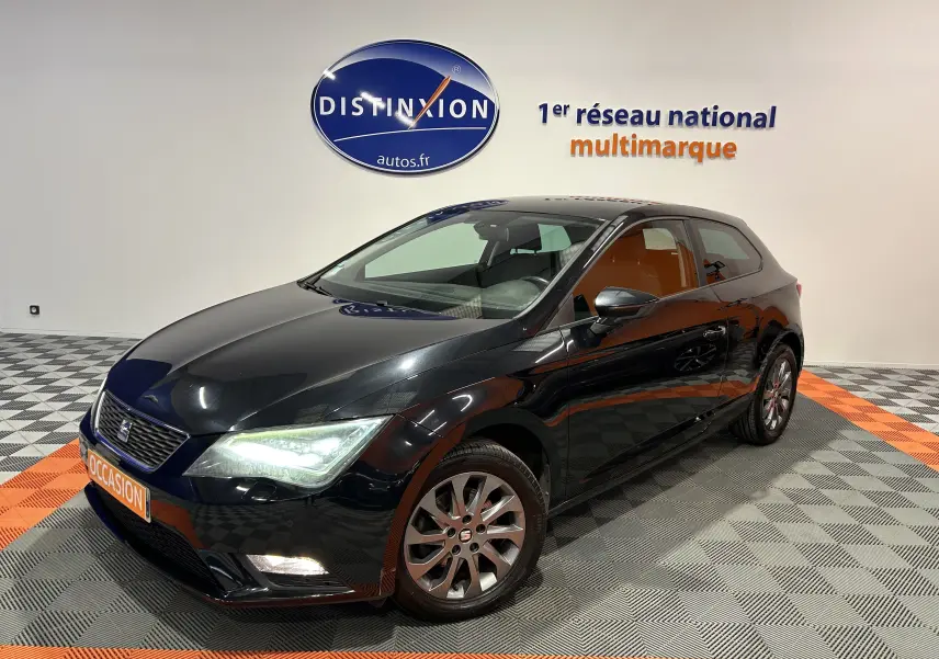 SEAT Leon noir vue 3/4 avant droit dans showroom avec éclairage mettant en valeur ses lignes et jantes.