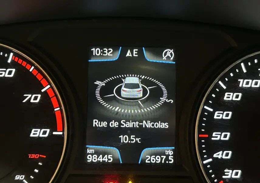 Gros plan sur l'écran central du tableau de bord d'une SEAT Leon noire, affichant la navigation GPS et l'odomètre.