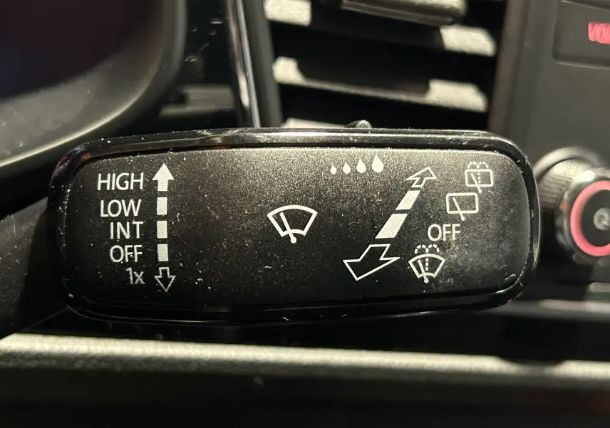 Gros plan sur la manette d'essuie-glace noire du tableau de bord d'une SEAT LEON noire, version 2014.