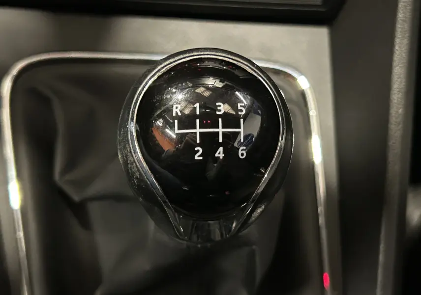 Gros plan sur le levier de vitesses noir de la SEAT LEON 1.4 TSI 122ch, boîte manuelle 6 rapports, avec marquages blancs.
