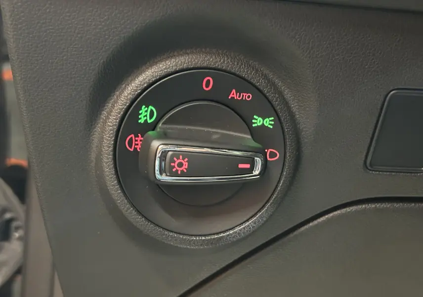 Gros plan sur le bouton de commande des phares du tableau de bord noir d'une SEAT LEON 2014.