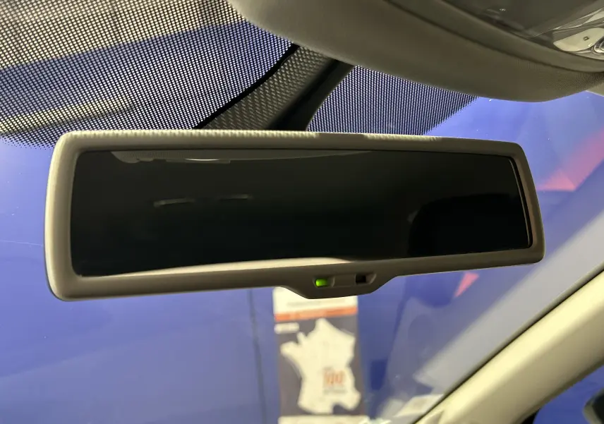 Rétroviseur intérieur avec fonction anti-éblouissement activée dans une SEAT Leon noire, vue de l'habitacle vers l'avant.