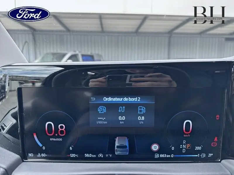 Vue rapprochée du tableau de bord numérique du Ford Transit Custom gris Magnetic, affichant l'ordinateur de bord.