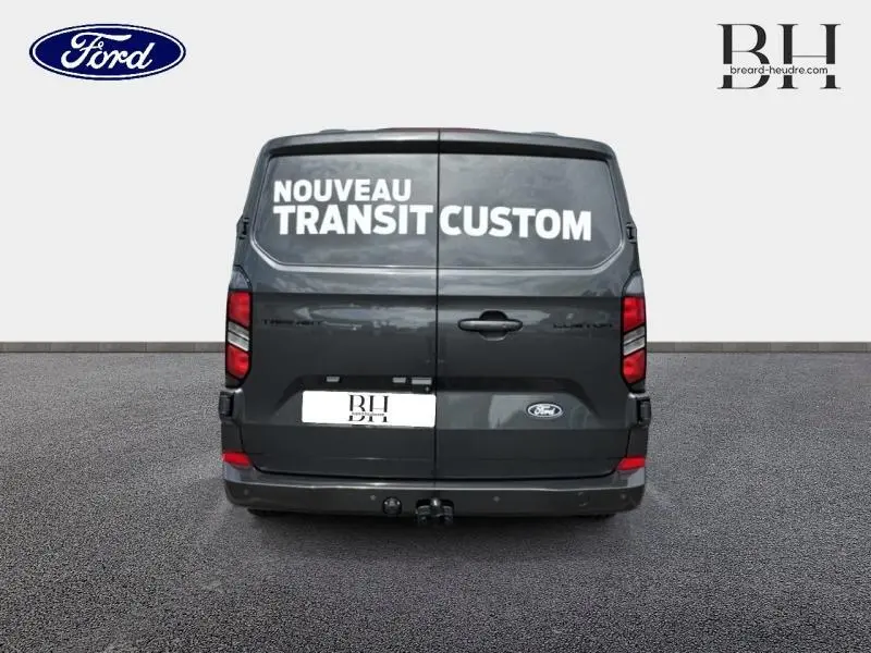 Vue arrière du Ford Transit Custom gris métallisé avec portes battantes fermées et crochet d'attelage visible.