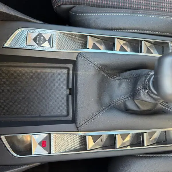 Vue rapprochée de la console centrale grise du DS3 2024, avec levier de vitesse manuel et boutons en métal brossé.