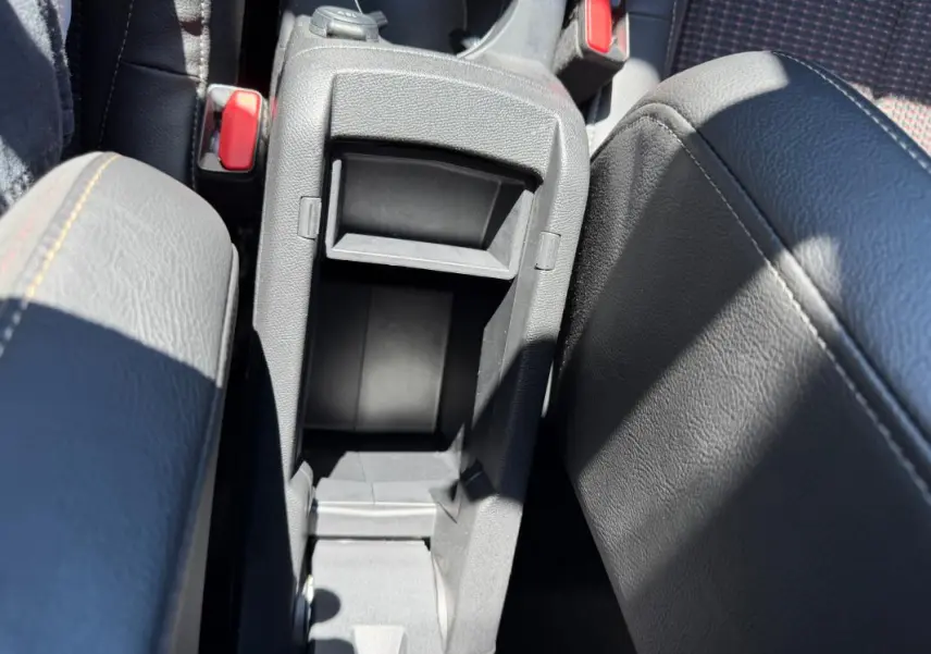 Vue plongeante sur la console centrale grise ouverte du DS3 100 BVM6 Performance Line 2024, avec accoudoirs en cuir noir.