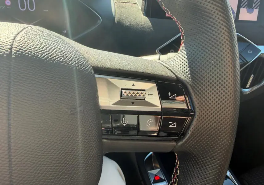 Gros plan sur le volant perforé avec commandes intégrées du DS3 100 BVM6 Performance Line gris, intérieur 2024.