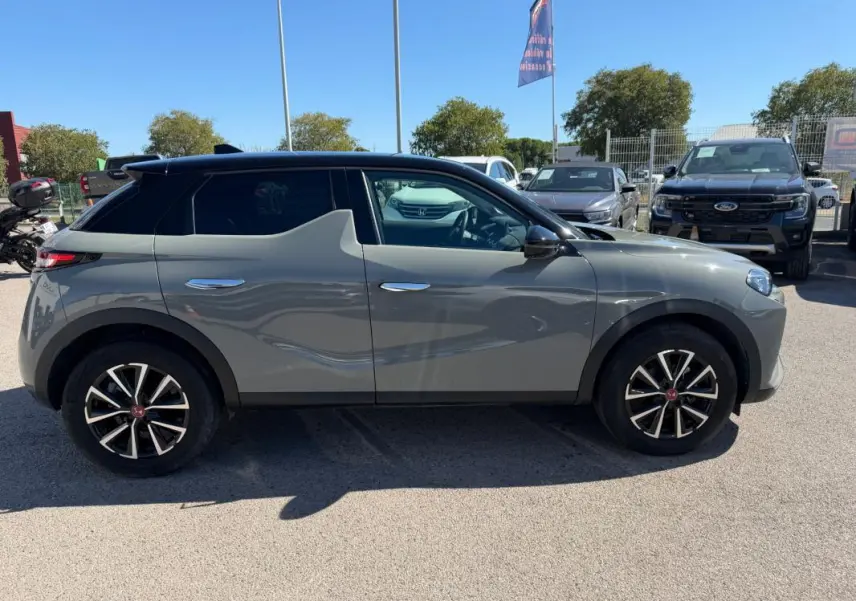 Vue de profil côté gauche d'un DS3 gris 2024 avec toit noir et jantes alliage distinctives en étoile.