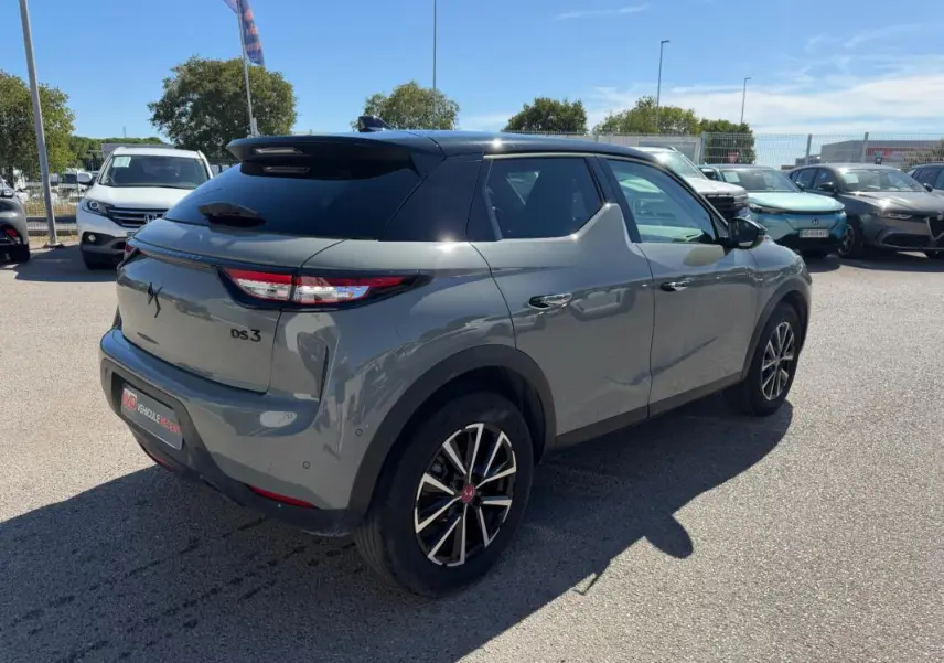 Vue 3/4 arrière droite d'une DS3 100 BVM6 Performance Line gris 2024 avec toit noir et jantes alliage distinctives.