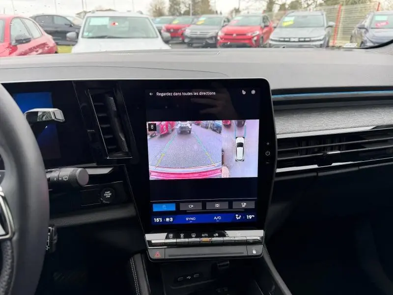 Vue intérieure du tableau de bord du Renault Austral 2025, écran central affichant la caméra de recul avec vue arrière et latérale.