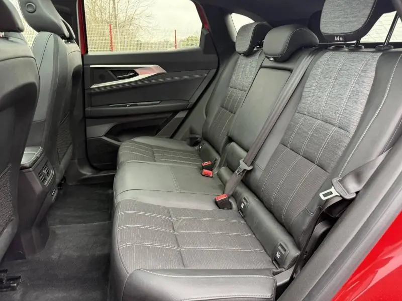 Vue intérieure côté droit des sièges arrière en tissu gris du Renault Austral 2025 Rouge Flamme, avec ceinture de sécurité visible.