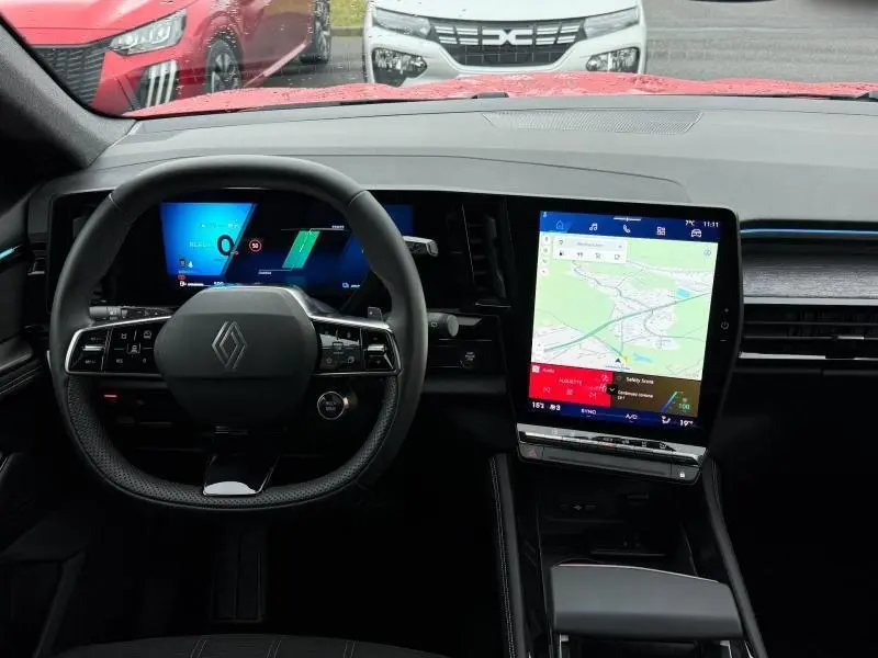 Vue intérieure du tableau de bord et volant de la Renault Austral 2025, avec écran tactile central et affichage numérique.