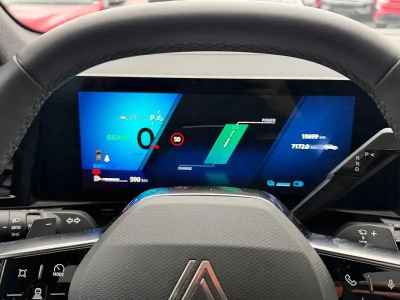 Vue rapprochée du tableau de bord numérique du Renault Austral 2025 hybride, avec affichage moderne et volant partiel visible.