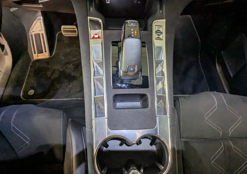 Vue plongeante sur la console centrale du DS7 gris laque, avec levier de vitesse automatique et garniture Alcantara noire.