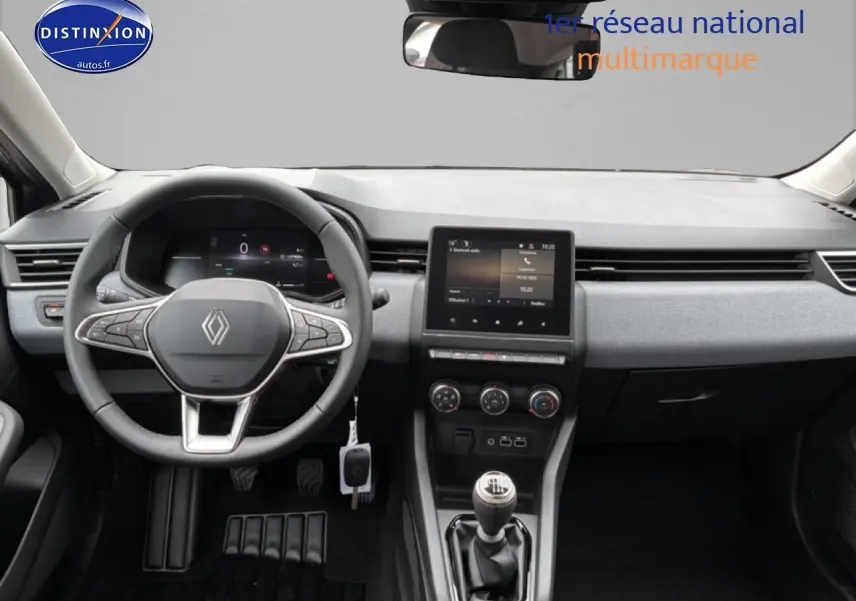 Vue intérieure avant du tableau de bord de la Renault Clio V gris schiste avec volant multifonction et écran tactile central.